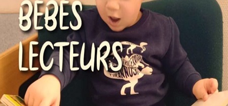 bebe qui tient un livre ouvert